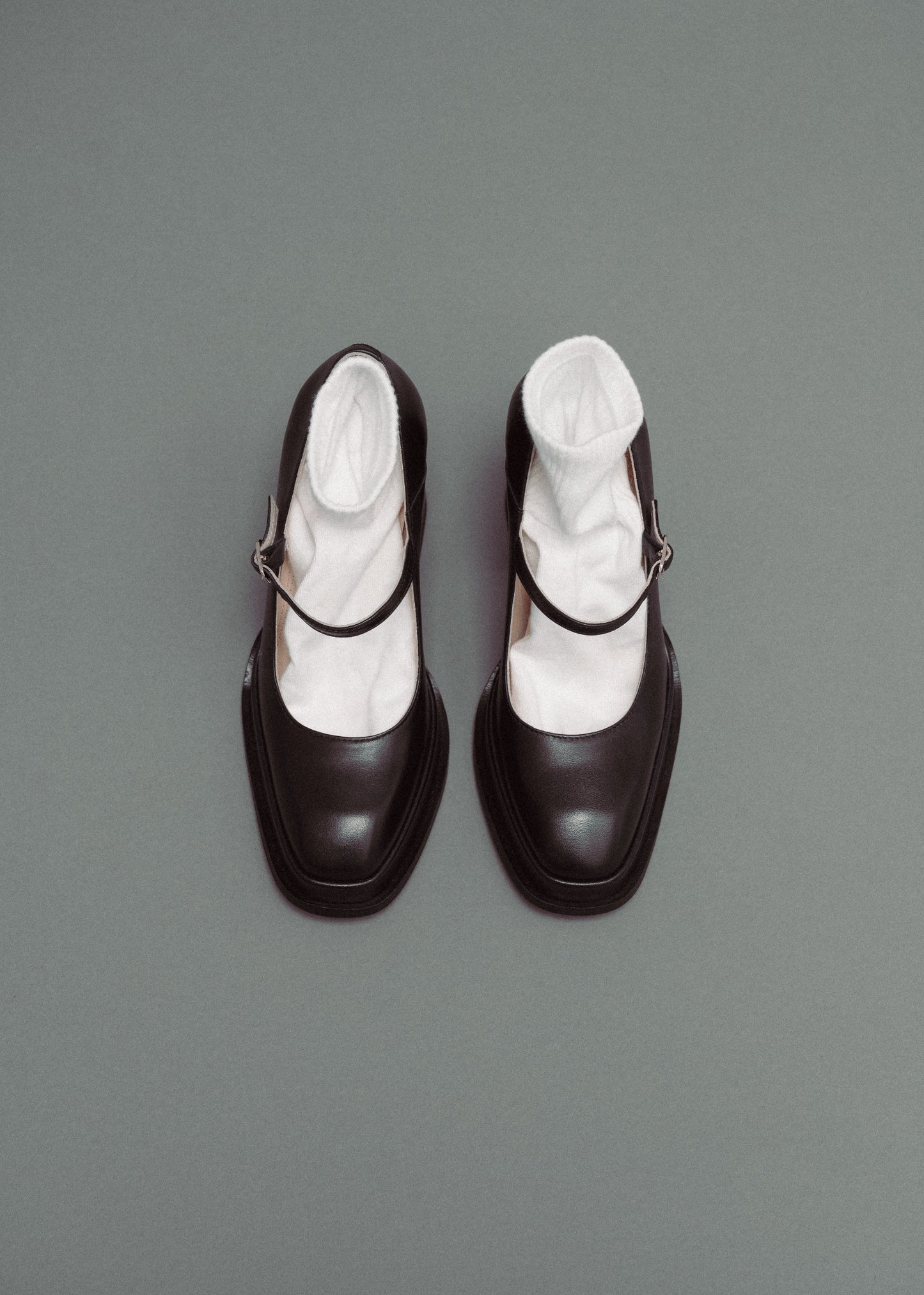 Black shoes with white socks on a gray background