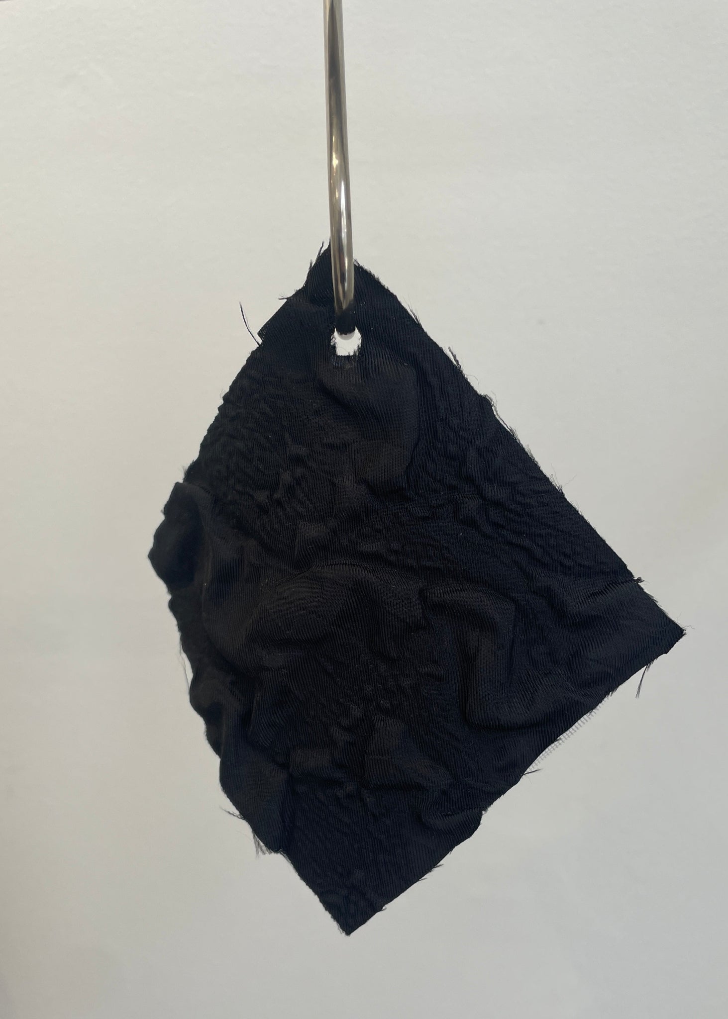 Black textured square object on a white background