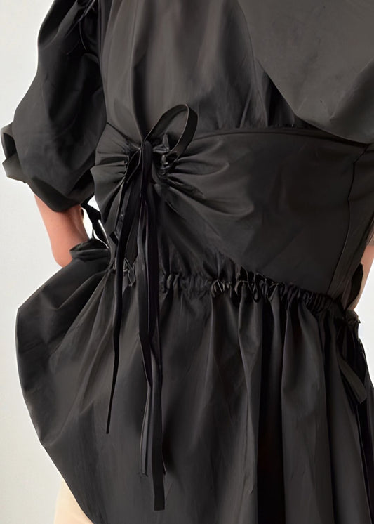 Black top with a bow detail on a mannequin against a white background