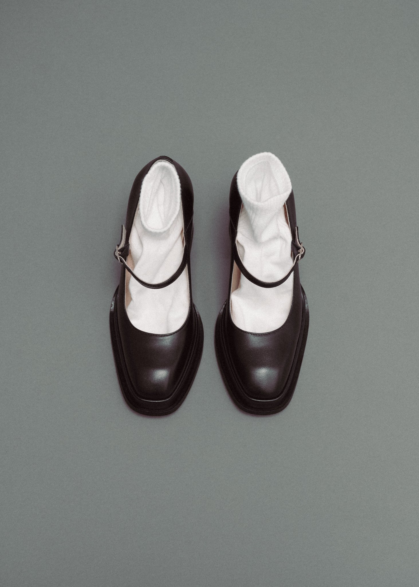 Black shoes with white socks on a gray background