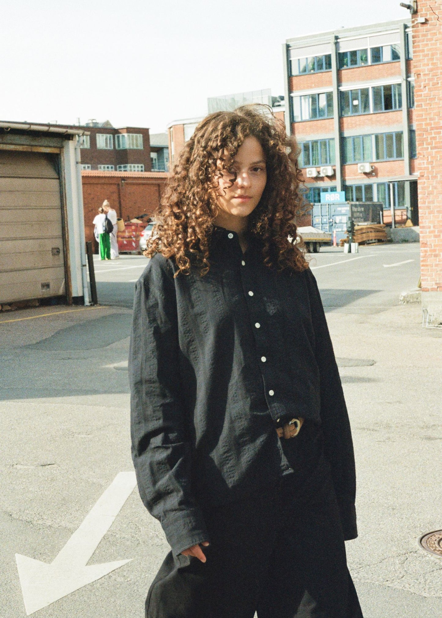 Person wearing a black jacket in an urban setting